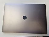 an apple laptop sitting on top of a white table