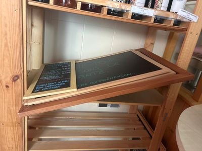 a wooden shelf with a chalk board on top of it