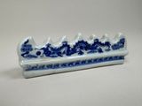un plat en forme de dragon bleu et blanc posé sur une table blanche