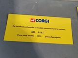 a yellow and red toy bus on display in a box