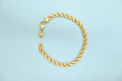 a close up of a gold chain bracelet on a blue surface