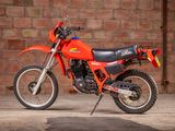 a red dirt bike parked in front of a brick wall