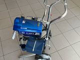 une petite machine bleue posée par terre dans une pièce