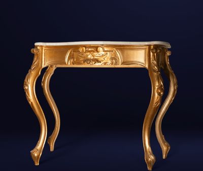 une console dorée ornée d'une tête de lion sur le plateau