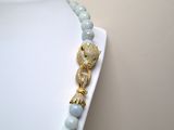 a necklace that has a gold and blue beaded necklace on a mannequin