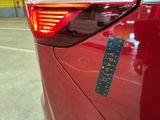 a sticker on the tail light of a red car
