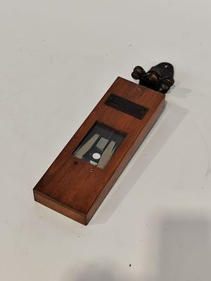 une petite horloge posée sur la table, à côté d'un couteau