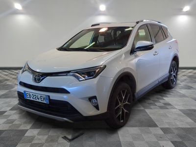 La Toyota RAV blanche est garée dans une pièce dont le sol est en damier.