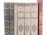 trois vieux livres sont alignés les uns à côté des autres sur une étagère