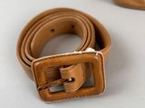 tan quilted belt and purse on a white surface