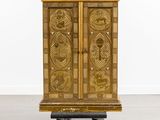 an antique wooden cabinet on wheels in a room with a white wall