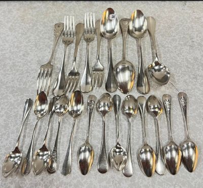 un grand nombre de cuillères et de fourchettes en argent disposées sur une table