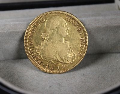 une image représentant une pièce d'or posée dans une boîte sur une table