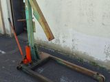 a green fork lifter sitting on the side of a building