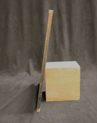 a picture of a piece of wood with a ruler sticking out of it