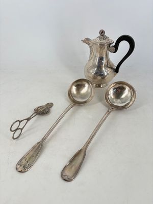three spoons and a teapot on a table with silverware