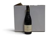 la bouteille de vin est à côté de la boîte sur la table