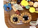 un plateau en bois sur lequel sont disposés plusieurs bijoux