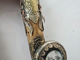 a person that is holding a wooden stick with a clock on it