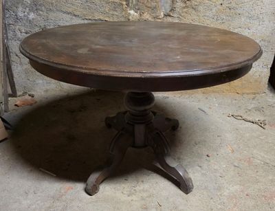 une petite table avec un plateau en bois, posée sur un sol en béton