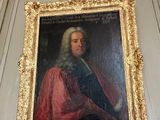 un tableau représentant un homme vêtu d'un manteau rouge, accroché au mur
