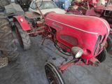 a red tractor that is parked in a garage
