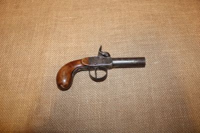 un gros plan sur un petit pistolet posé sur un tissu marron
