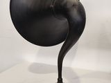 a black object on a table with a white wall behind it