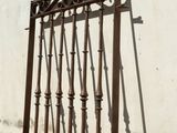 a metal fence that is leaning against a white wall