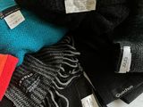 many different colors of hats and scarves on a table