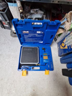 une boîte à outils bleue contenant une petite balance à l'intérieur