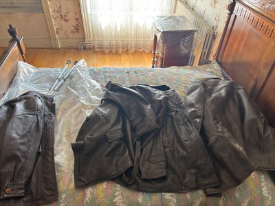 a bed with a jacket on it and a pair of pants on the bed