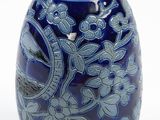 a blue vase with a floral design on it