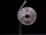 a glass sculpture of a spiral shaped object on a table