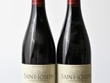deux bouteilles de vin posées l'une à côté de l'autre sur une table en bois