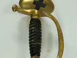 a gold sword with a cross on it on a white surface