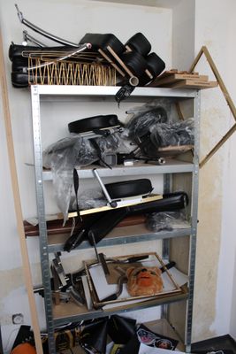 une étagère métallique sur laquelle sont posés de nombreux objets, dans une pièce