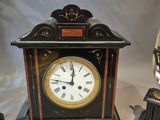 a clock sitting on a table next to two other clocks