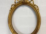 a gold picture frame sitting on top of a table next to a wall