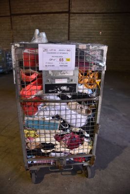 a metal cart with many items in it in a warehouse