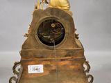 a gold clock with an angel sitting on top of it