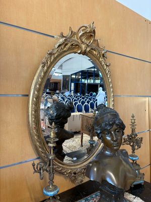 une statue représentant une femme assise devant un miroir