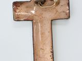 a ceramic cross with a gold ring on it