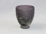 a purple vase with a bird on it sitting on a table