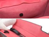 the inside of a pink purse with a zipper open and a hand holding it