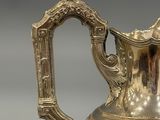 a silver pitcher that is sitting on a table