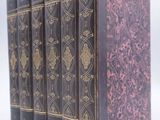 six livres sont alignés sur une surface blanche