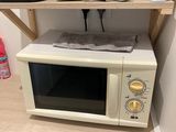 un micro-ondes posé sur une étagère en bois à côté d'un four à micro-ondes