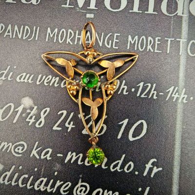 une photo d'un pendentif en or orné d'une pierre verte