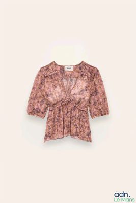 chemisier rose avec un imprimé floral sur le devant et un décolleté en V